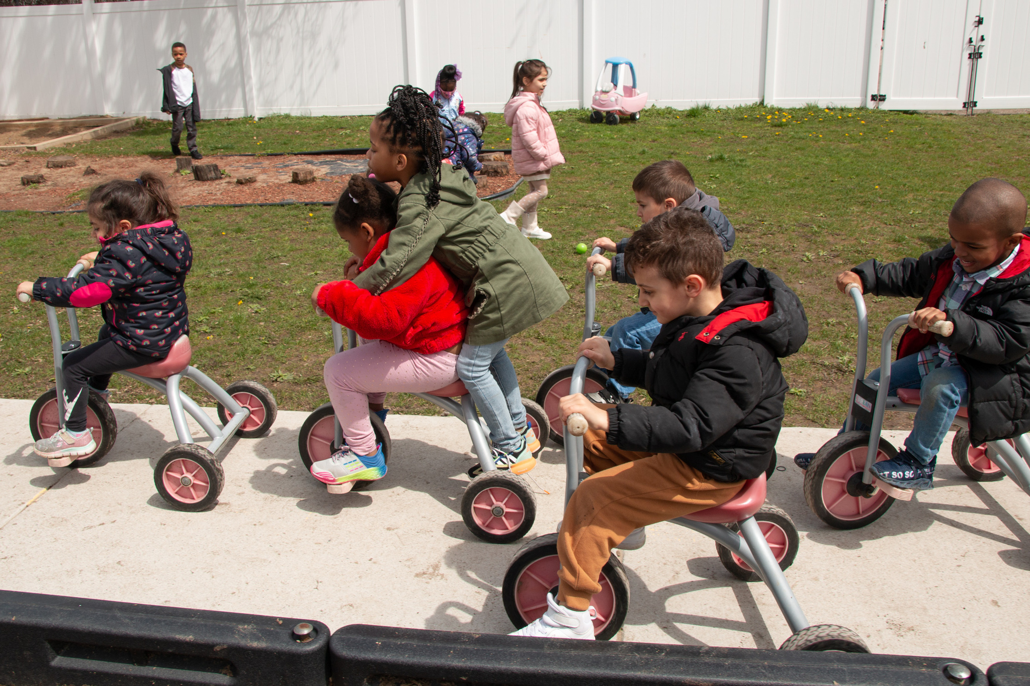 GSRP Students on 3-wheel bikes outside.